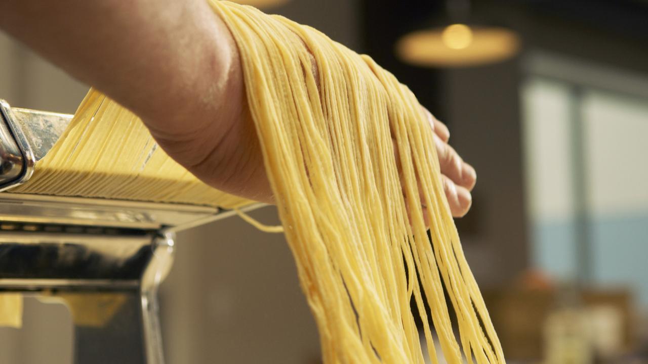 Spaghetti werden mit einer Nudelmaschine hergestellt.